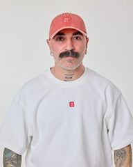 man wearing Orange Washed Cap with Love Myself embroidered in white