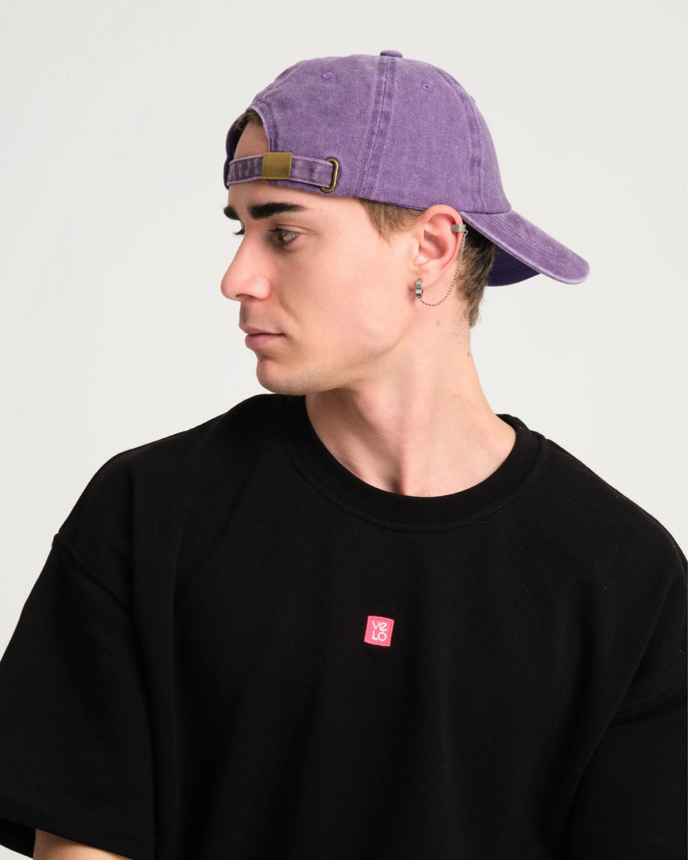 man wearing back side of purple washed cap with Love You, Bye slogan 