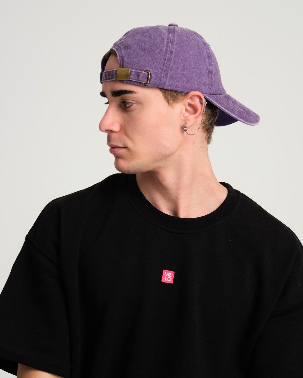 side view of a man wearing Shoreditch Purple Washed Cap backwards