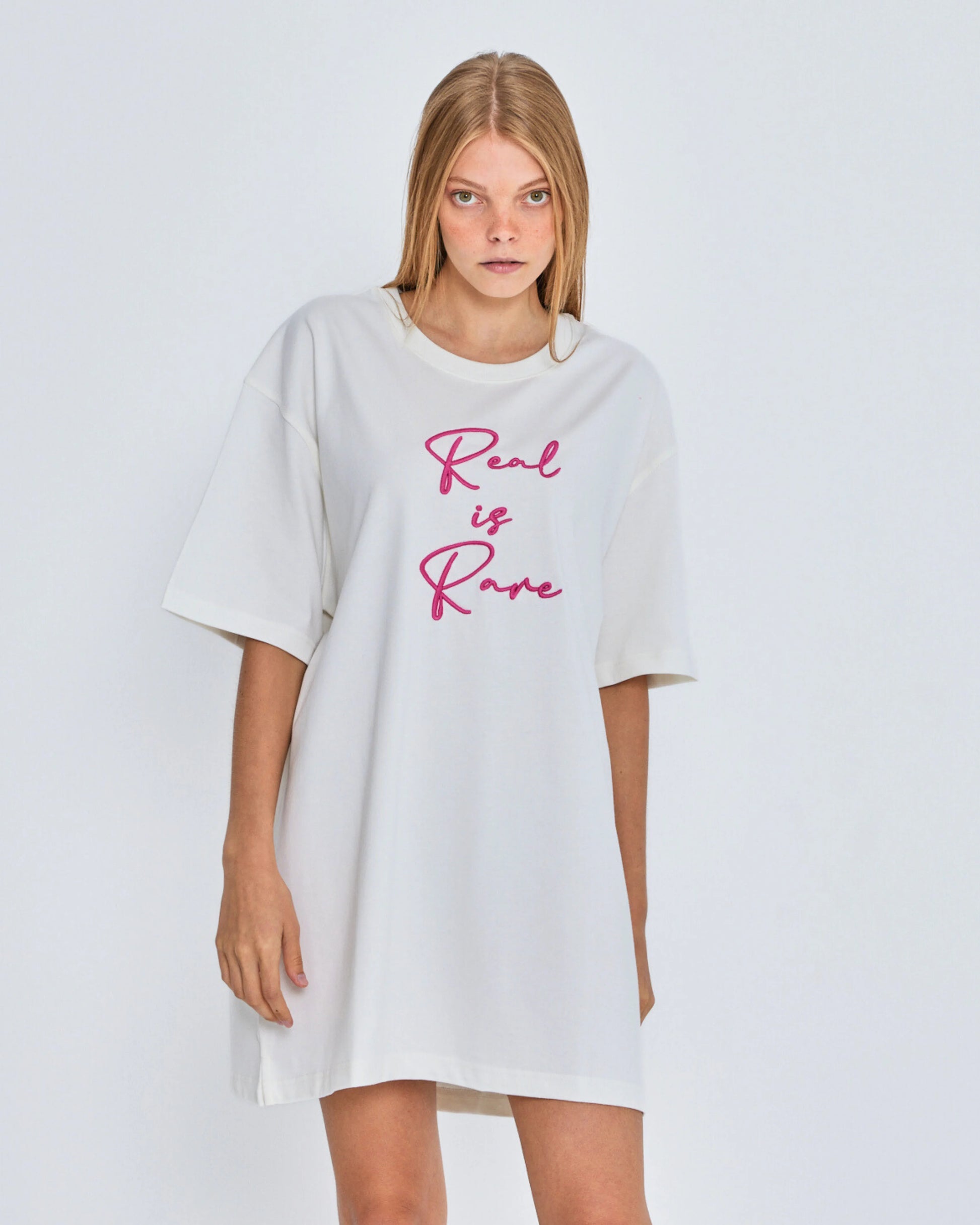 White oversized t-shirt with 'Real is Rare' text on a plain background