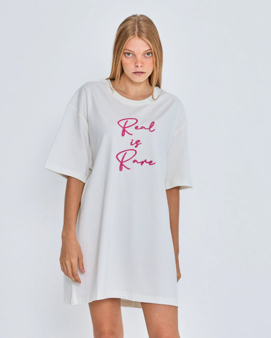 White oversized t-shirt with 'Real is Rare' text on a plain background