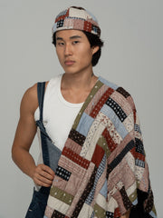 Person wearing Rustwork Multicolor Docker Hat over a white tank top with a plain background