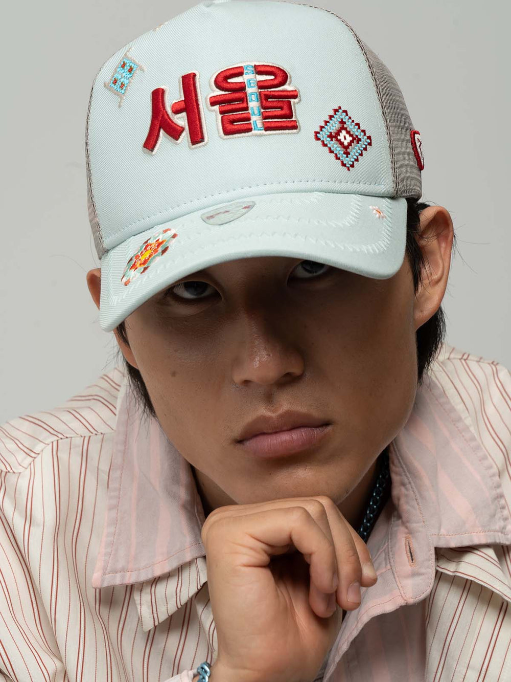 Person wearing Seoul Mint Green Trucker Hat on a gray background