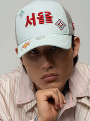 Person wearing Seoul Mint Green Trucker Hat on a gray background