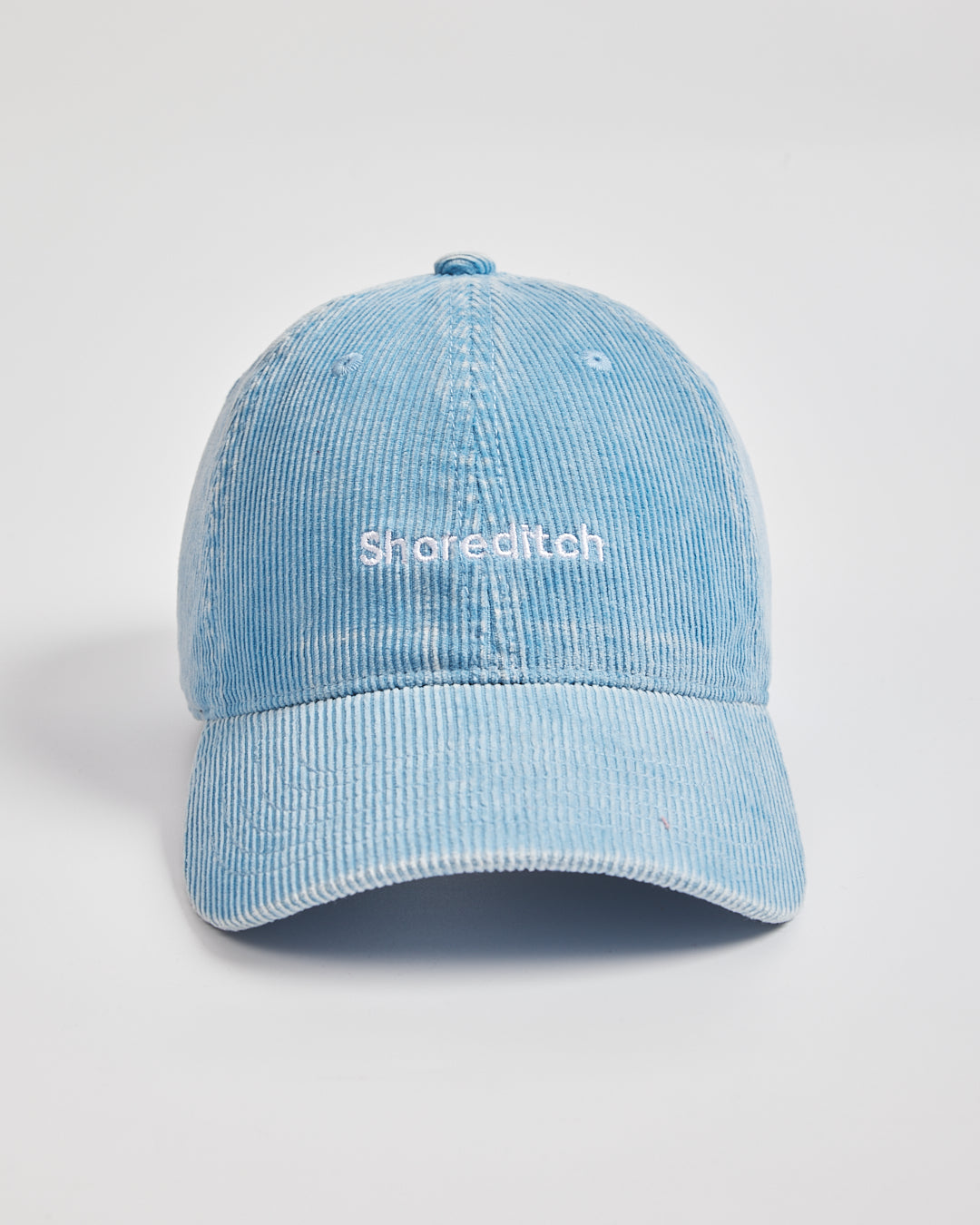 Light blue cap with 'Shoreditch' text on a light gray background