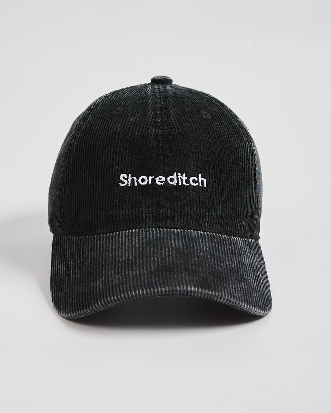Black cap with 'Shoreditch' text on a light gray background