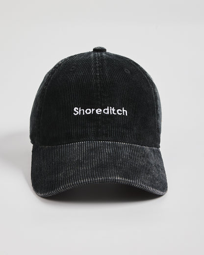 Black cap with 'Shoreditch' text on a light gray background
