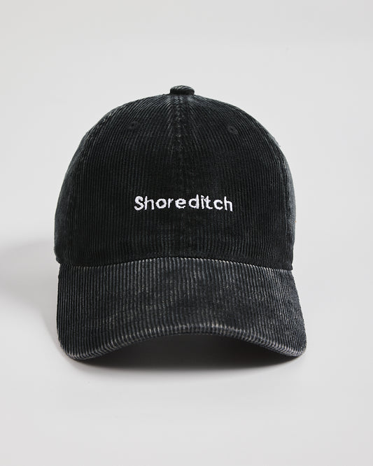 Black cap with 'Shoreditch' text on a light gray background