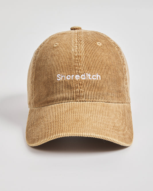 Camel cap with 'Shoreditch' text on a light gray background