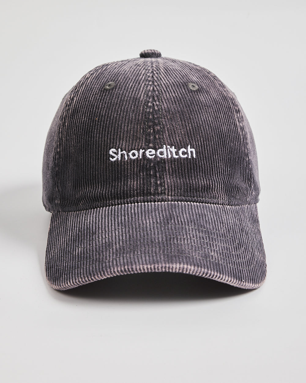 Gray corduroy cap with 'Shoreditch' text on a light gray background