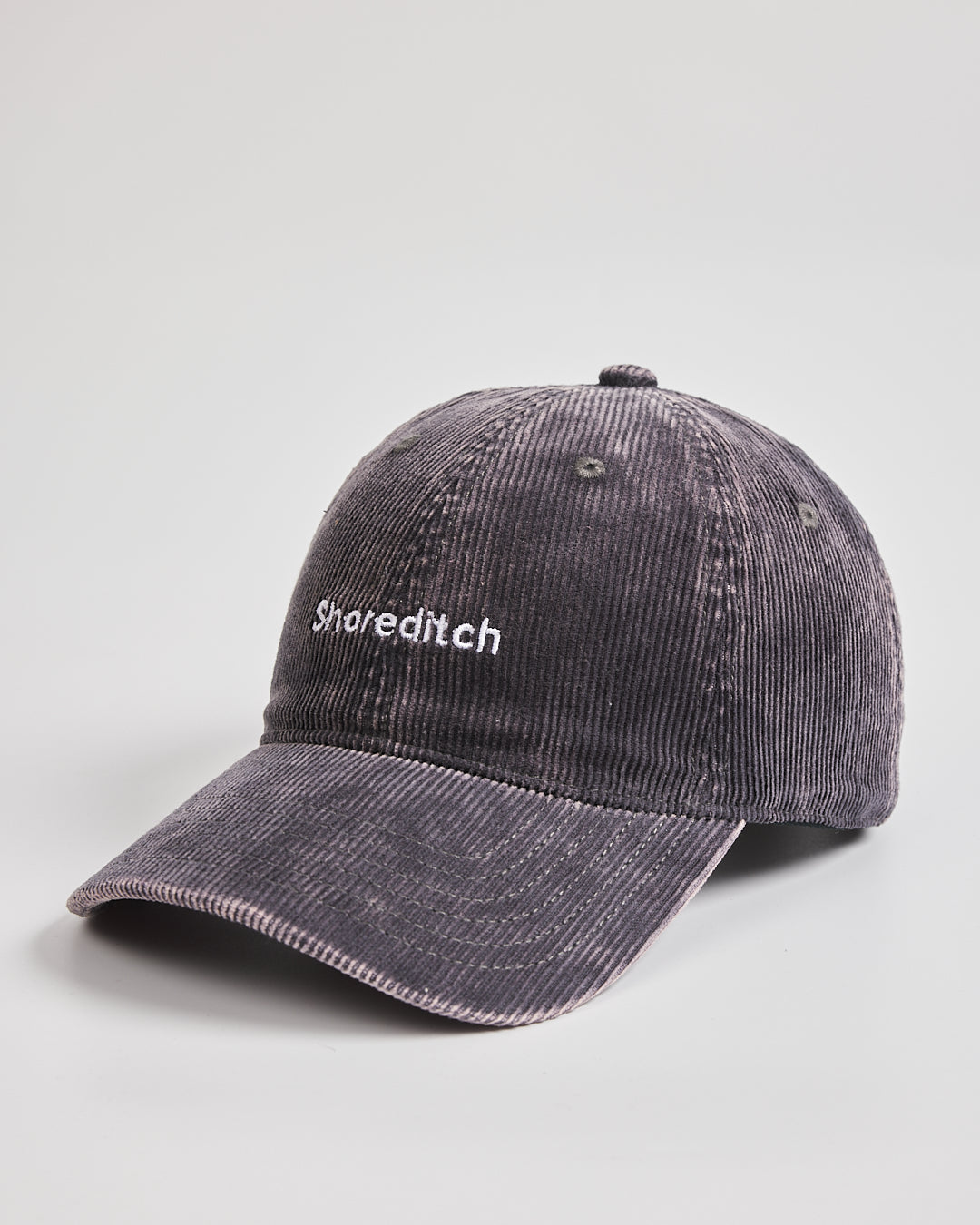 Grey corduroy cap with text on a light gray background