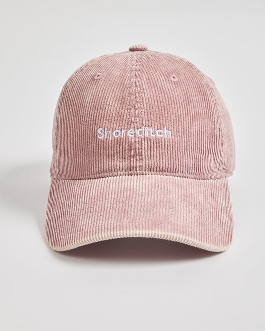 Pink corduroy cap with 'Shoreditch' text on a light gray background