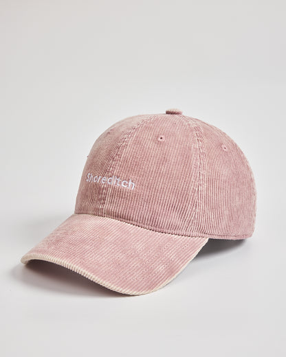 Pink corduroy cap with 'Shoreditch' embroidery on a light gray background