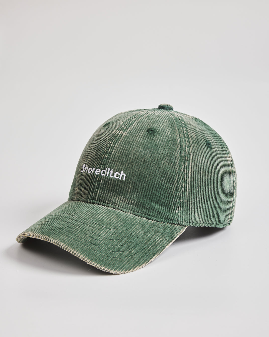 Green cap with 'Shoreditch' text on a light gray background