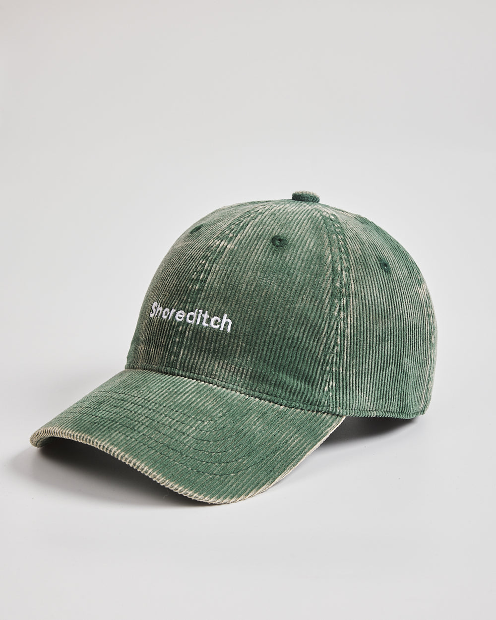 Green cap with 'Shoreditch' text on a light gray background