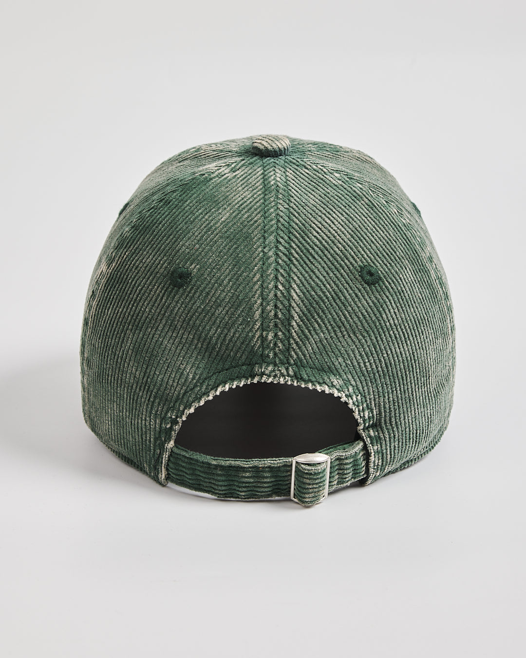 Green corduroy cap on a light gray background