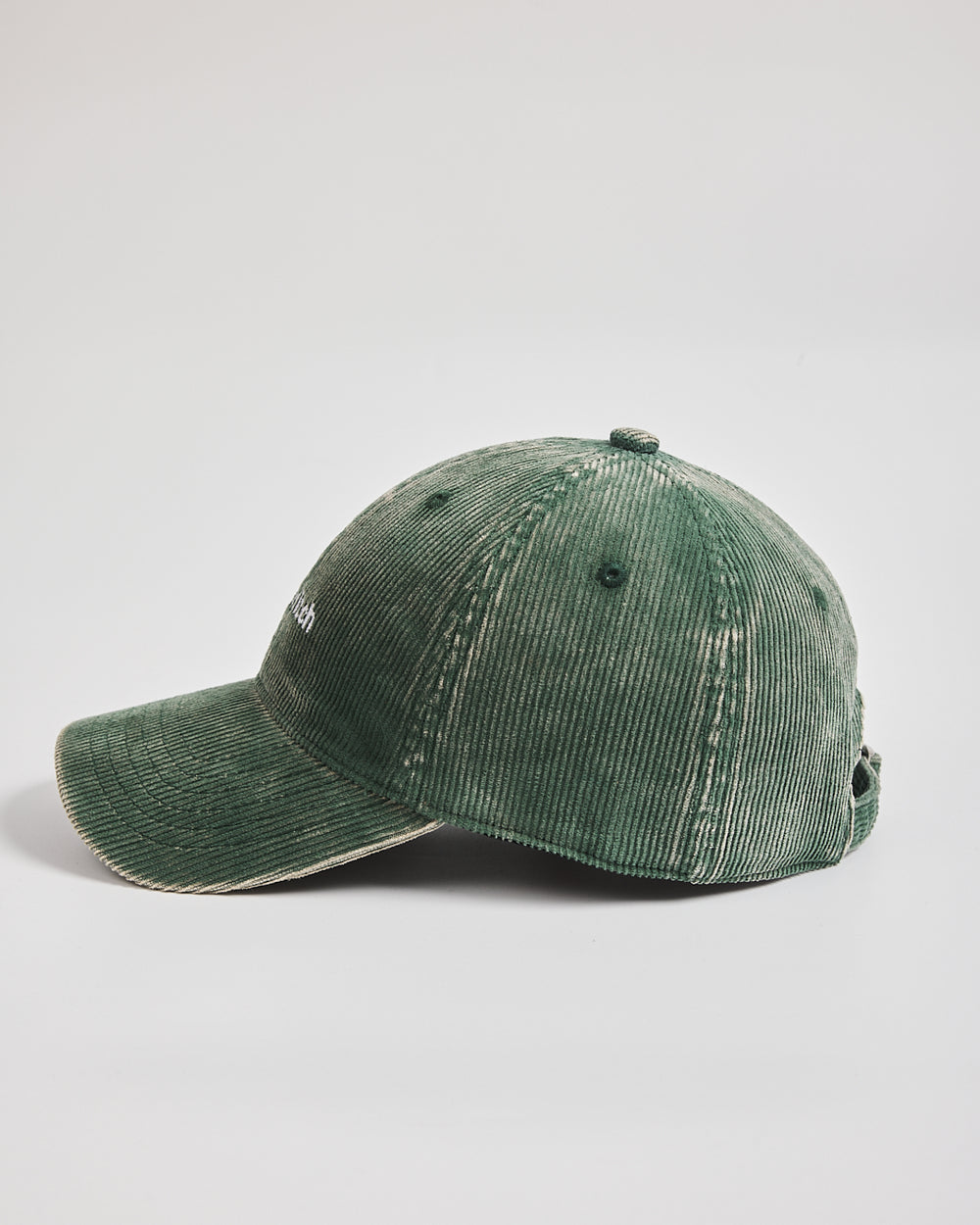 Green corduroy cap on a light gray background