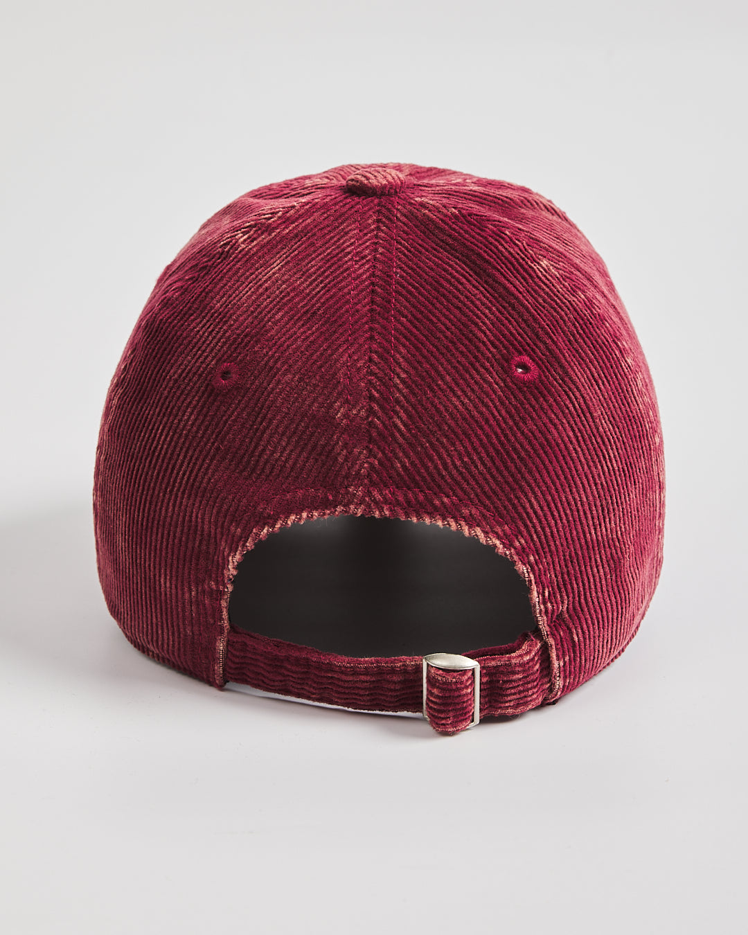 Maroon corduroy cap on a light gray background