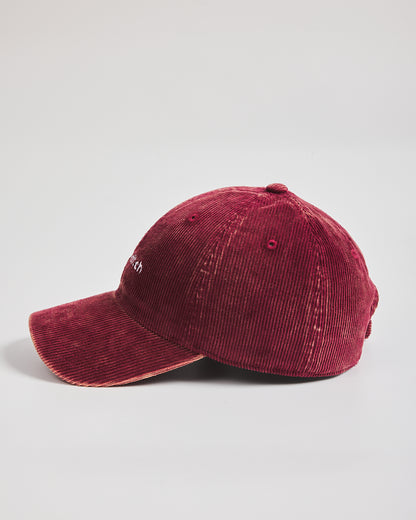 Red corduroy cap on a light gray background
