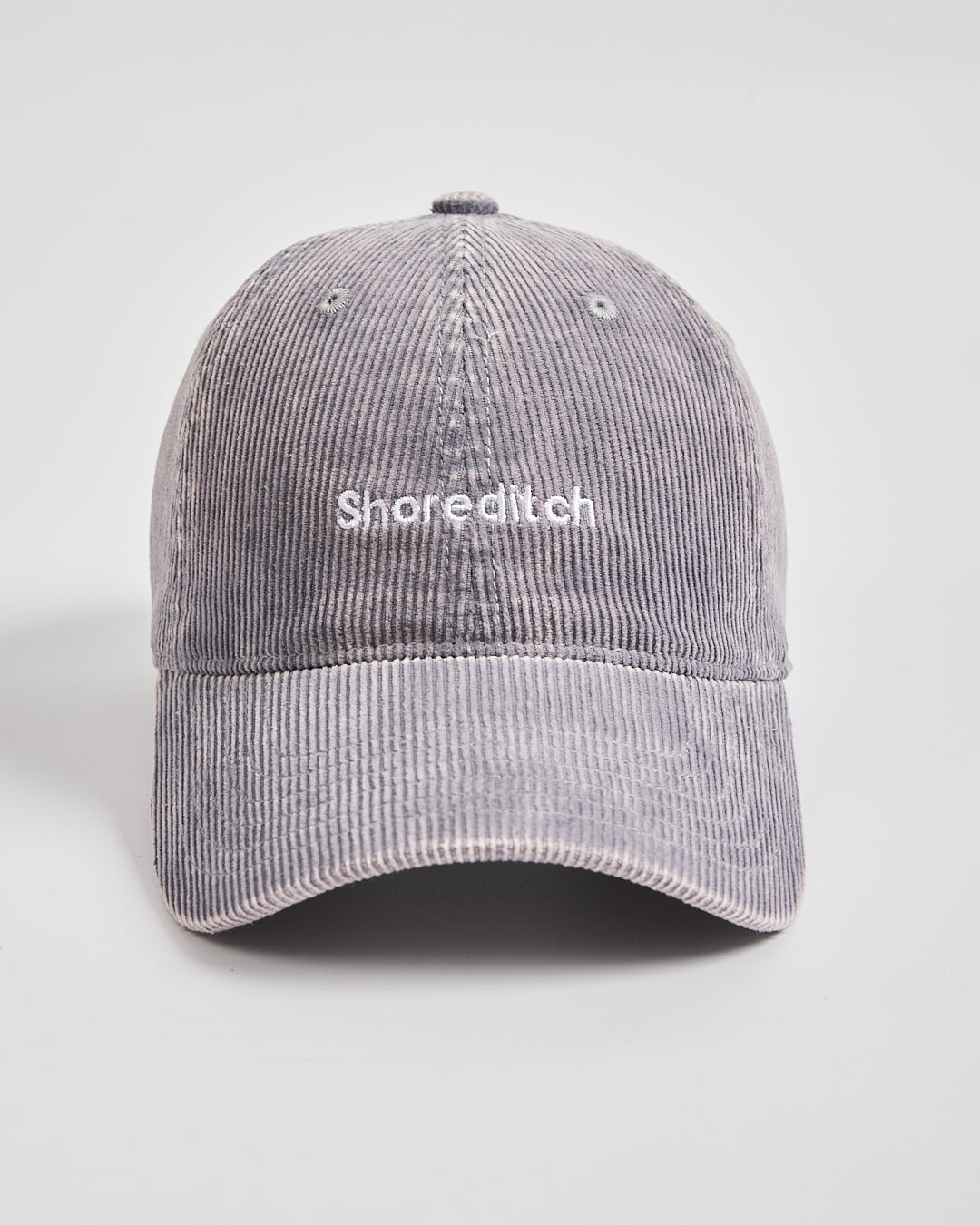 Gray corduroy cap with 'Shoreditch' text on a light gray background