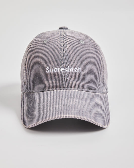 Gray corduroy cap with 'Shoreditch' text on a light gray background