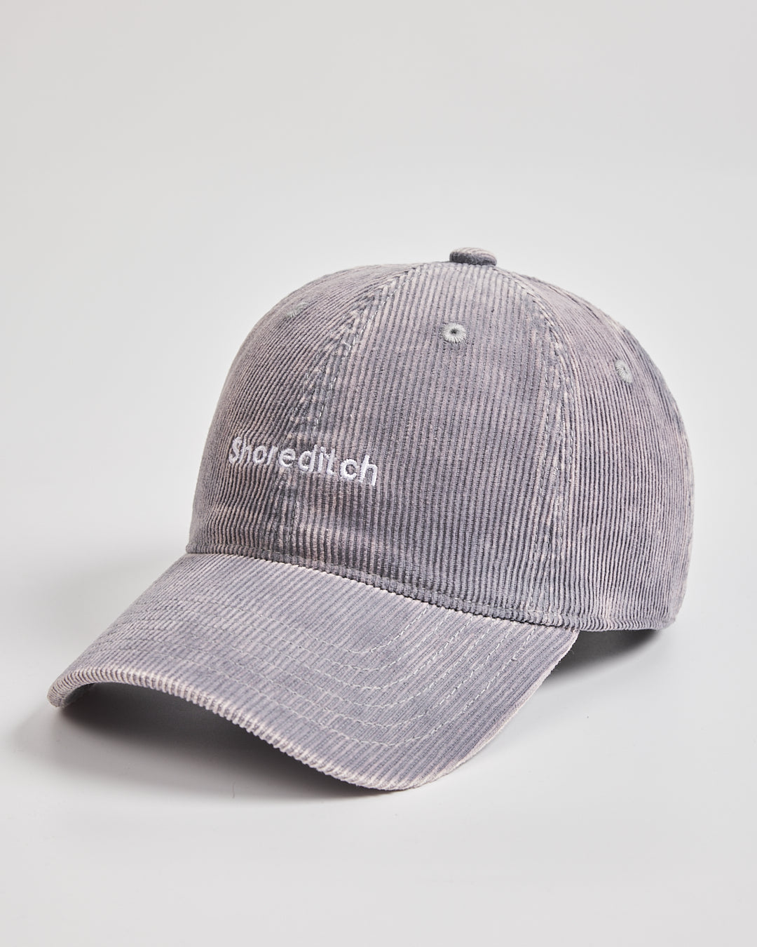 Gray corduroy cap with 'Shoreditch' branding on a light gray background