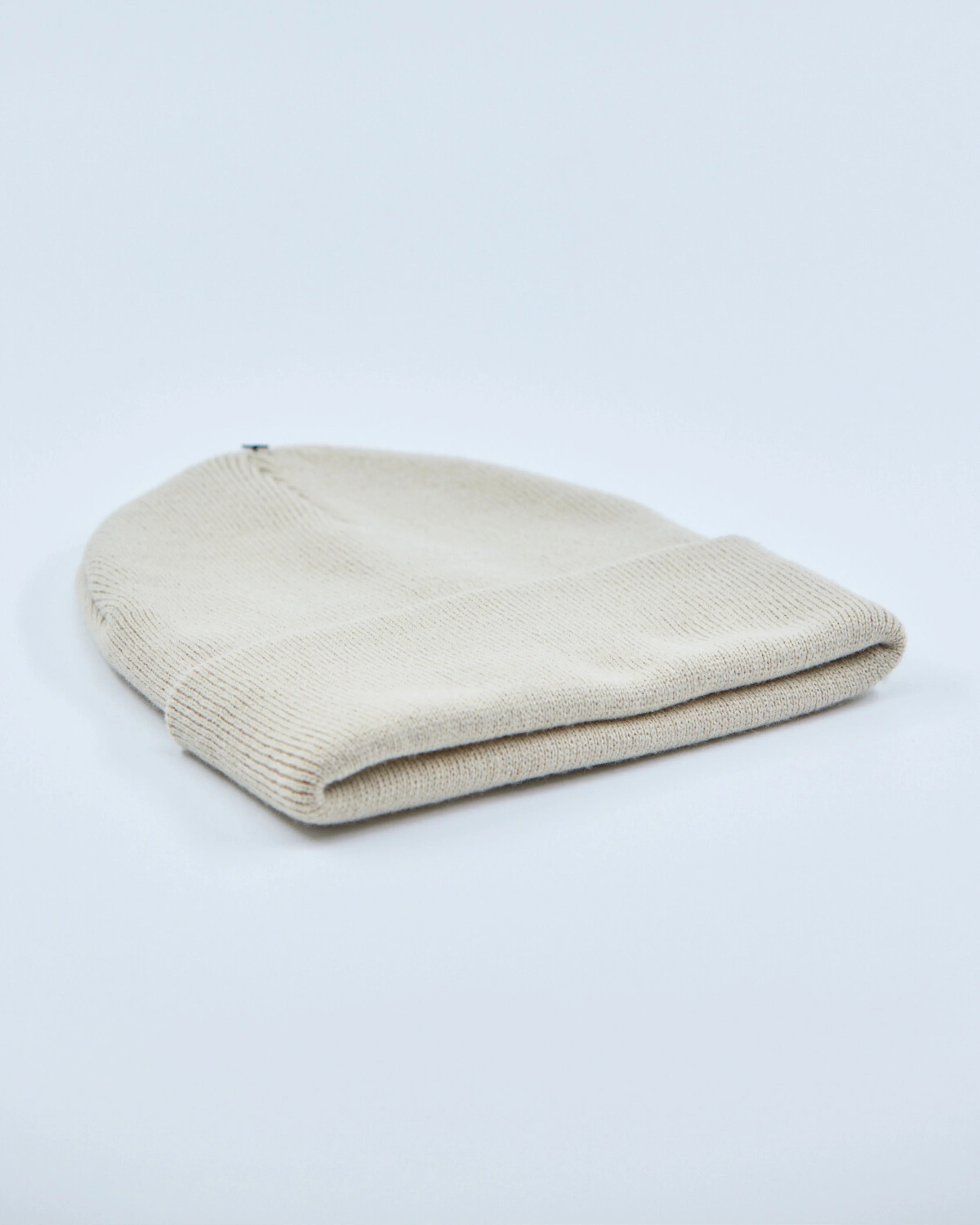 stone white beanie hat on a light gray background