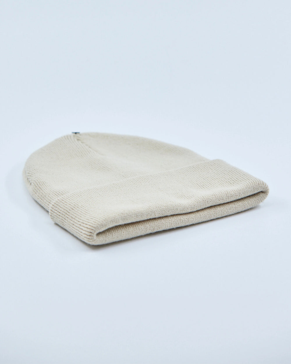 stone white beanie hat on a light gray background