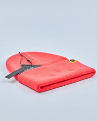 Tomato red beanie with a tag on a light gray background