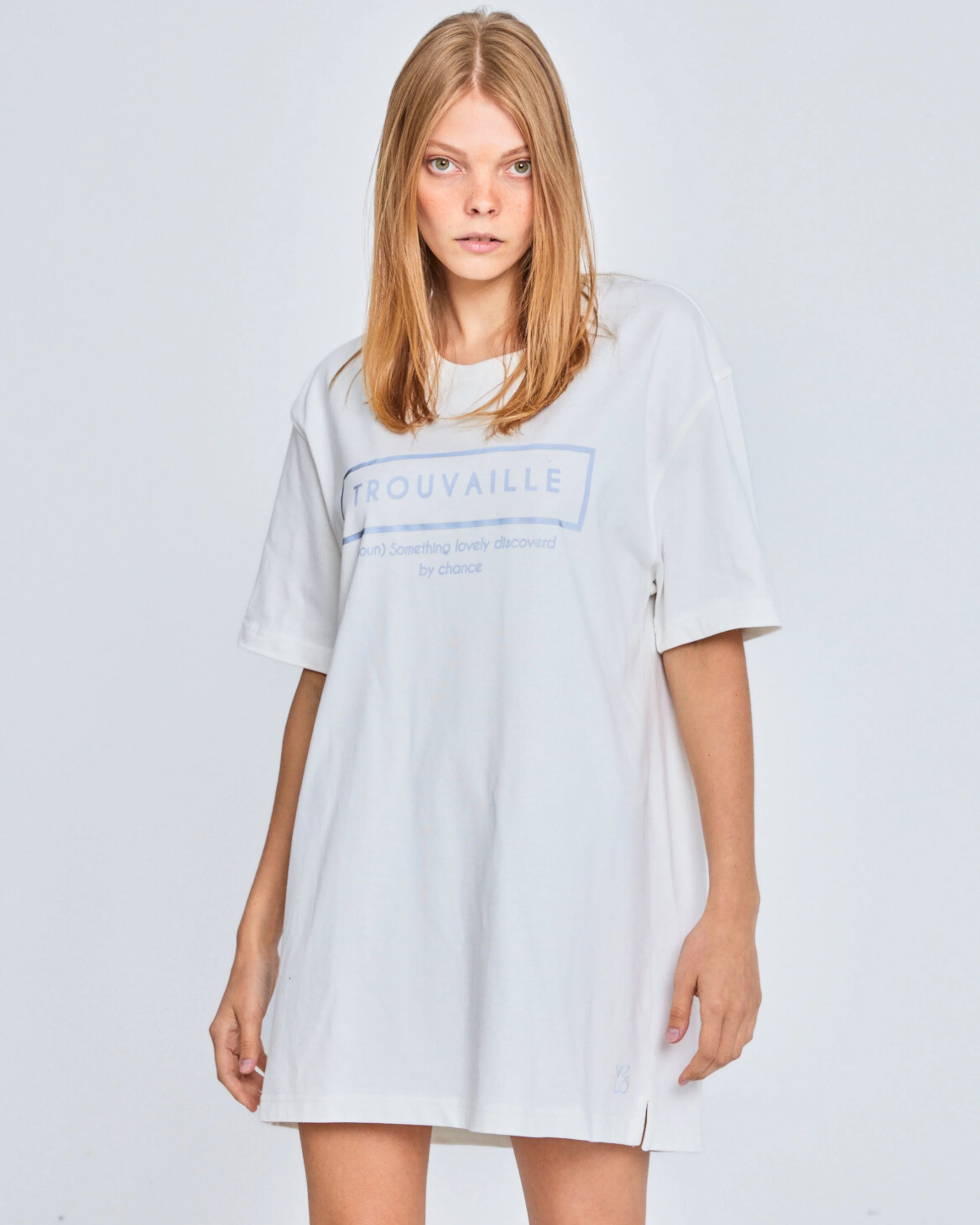 Woman wearing a light gray t-shirt dress with 'Trouvaille' logo on a white background