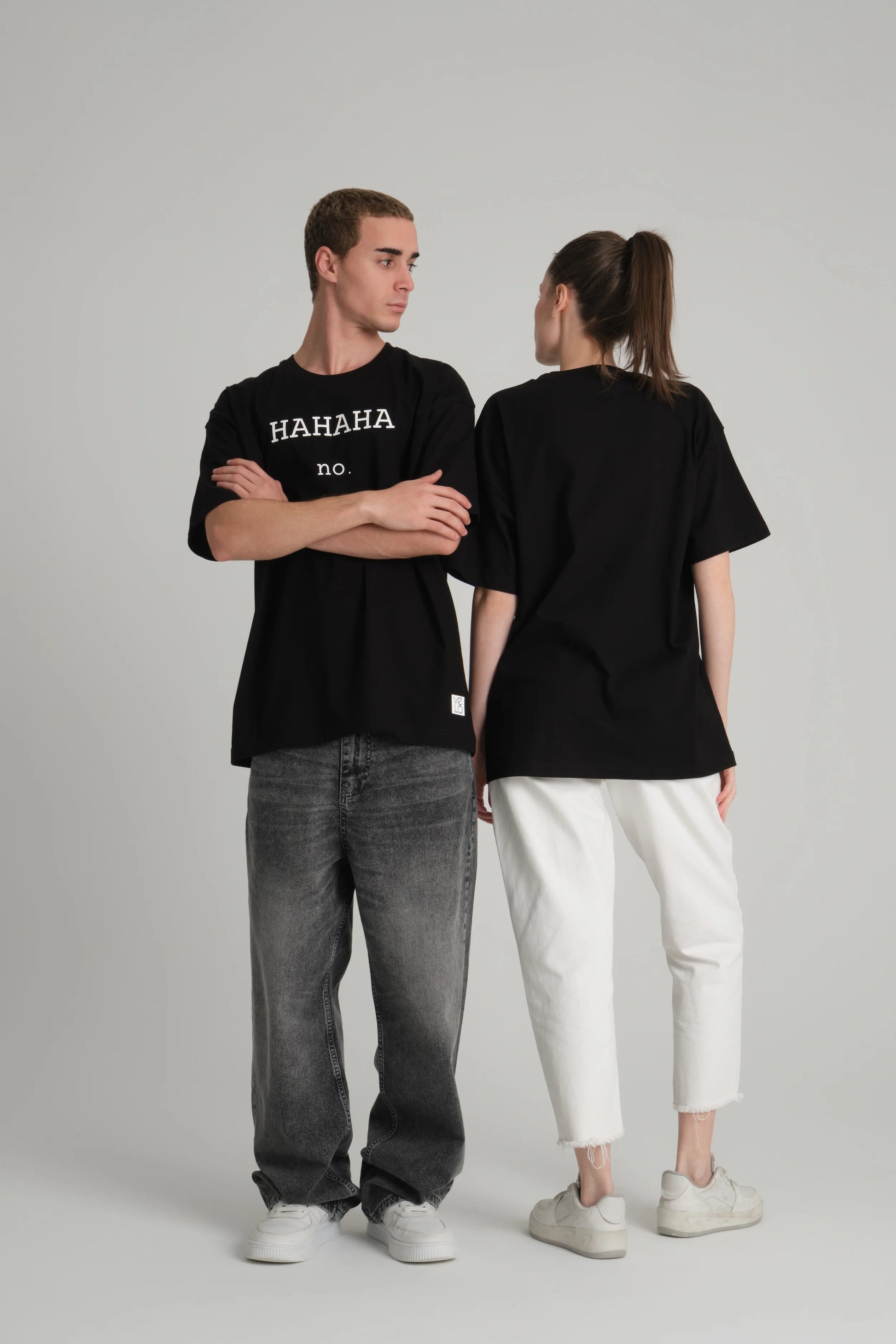 front view of male and back view of female model wearing hahaha no black tee
