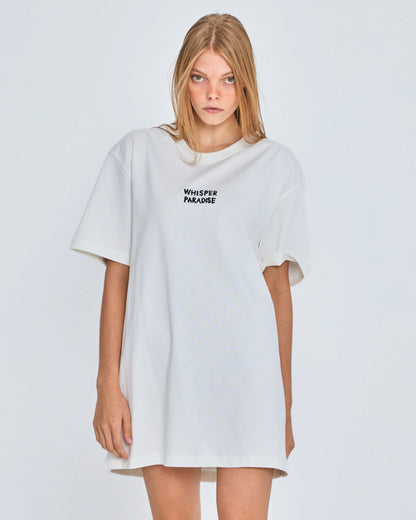 Woman wearing a white oversized t-shirt with text on a plain background
