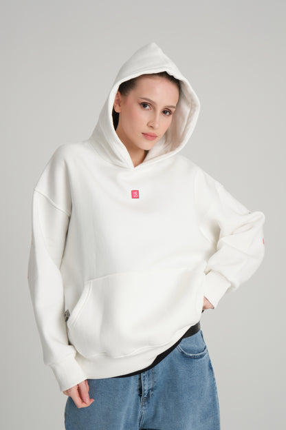 Person wearing a white hoodie with a small red logo on a gray background
