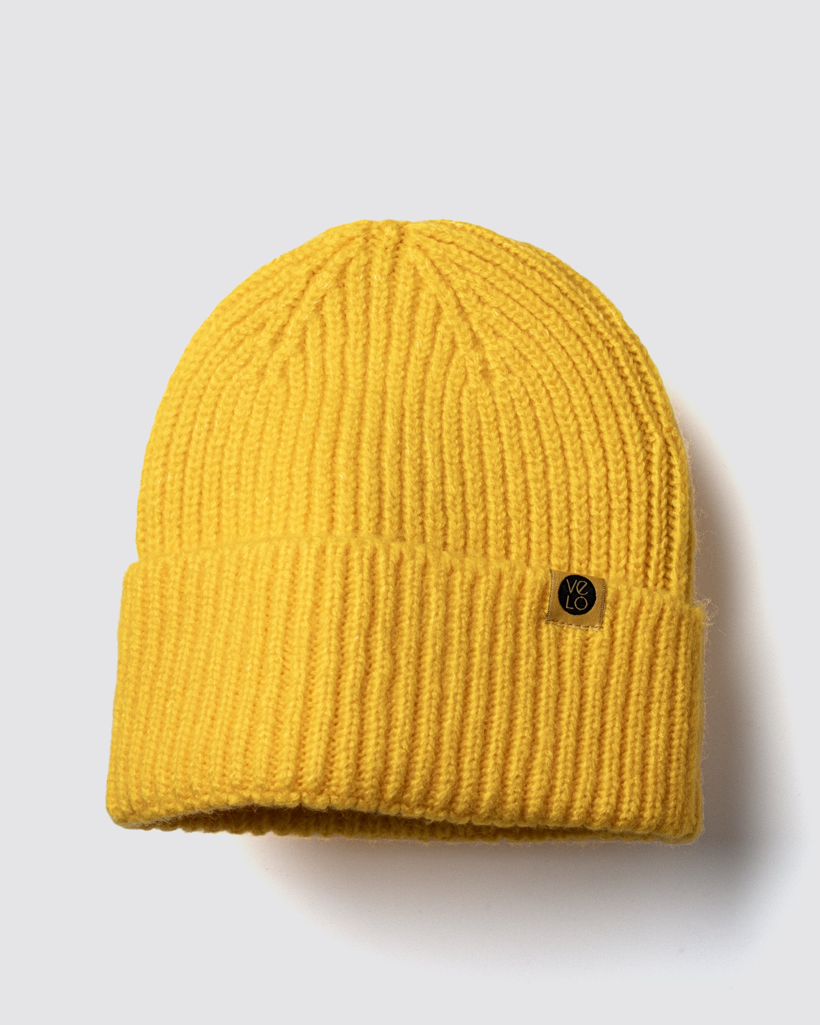 Yellow Lux Beanie on a light gray background