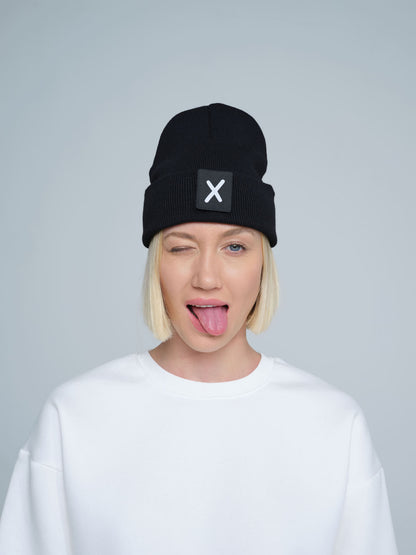 women wearing black beanie with X letter patch on it