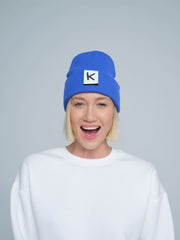 female model wearing blue beanie with K letter patch on it 