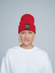 A person wearing a red beanie with a 'crown' design on the cuff, and a white t-shirt.