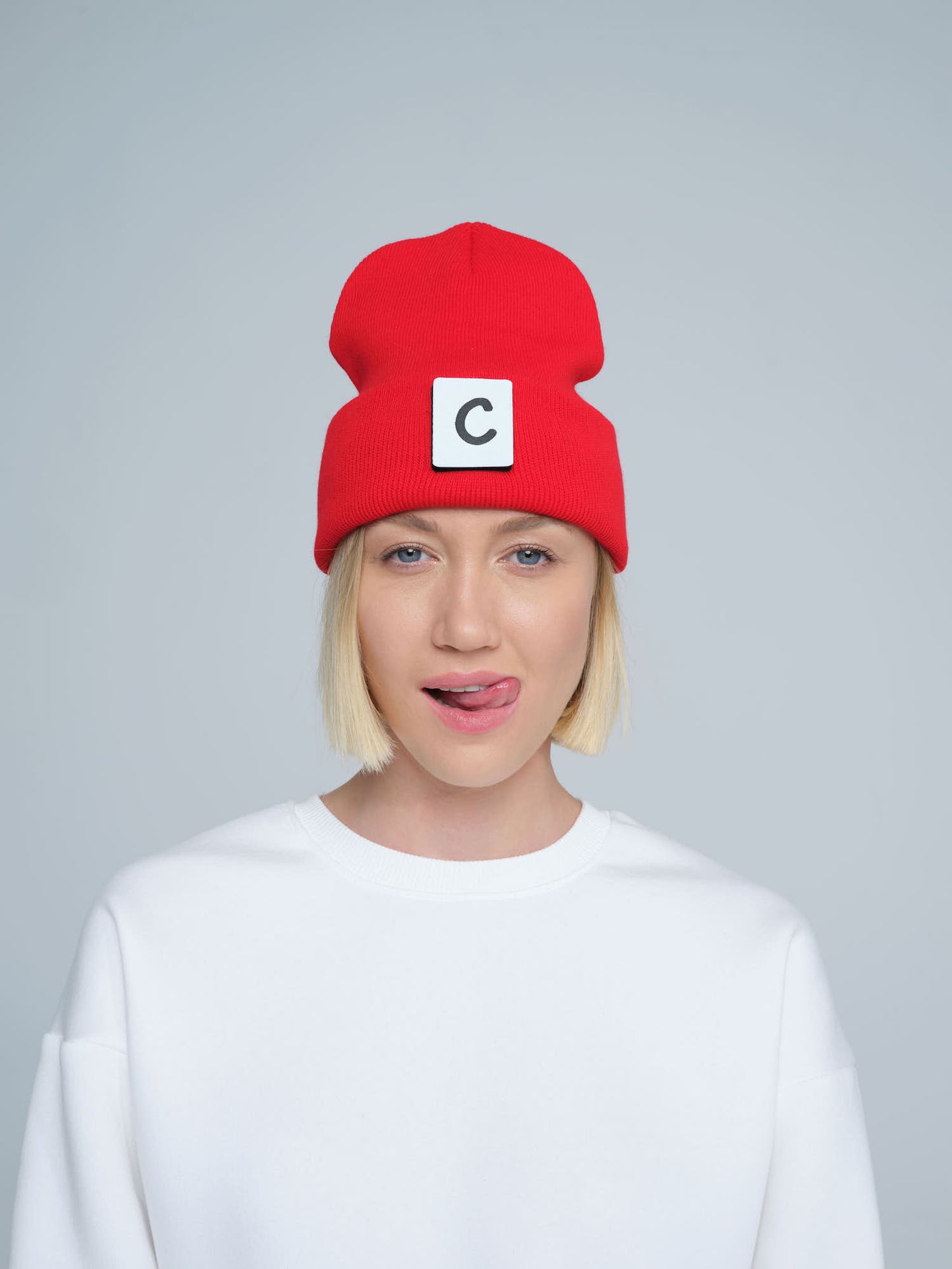 women wearing hot red beanie with 'C' letter patch on it