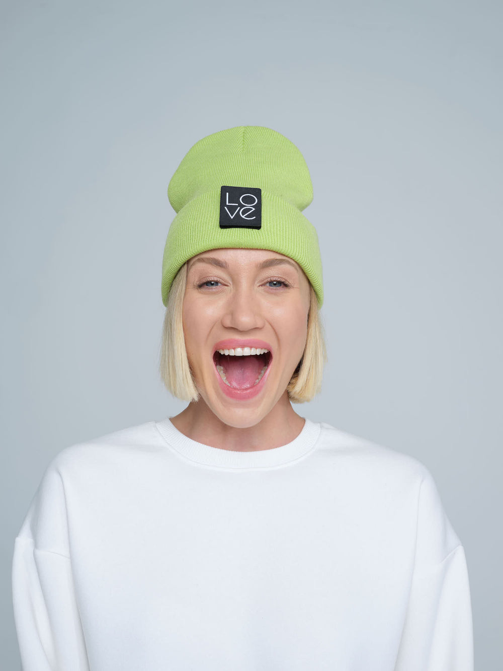 model wearing light green patch ready beanie with LOVE text patch on the front 