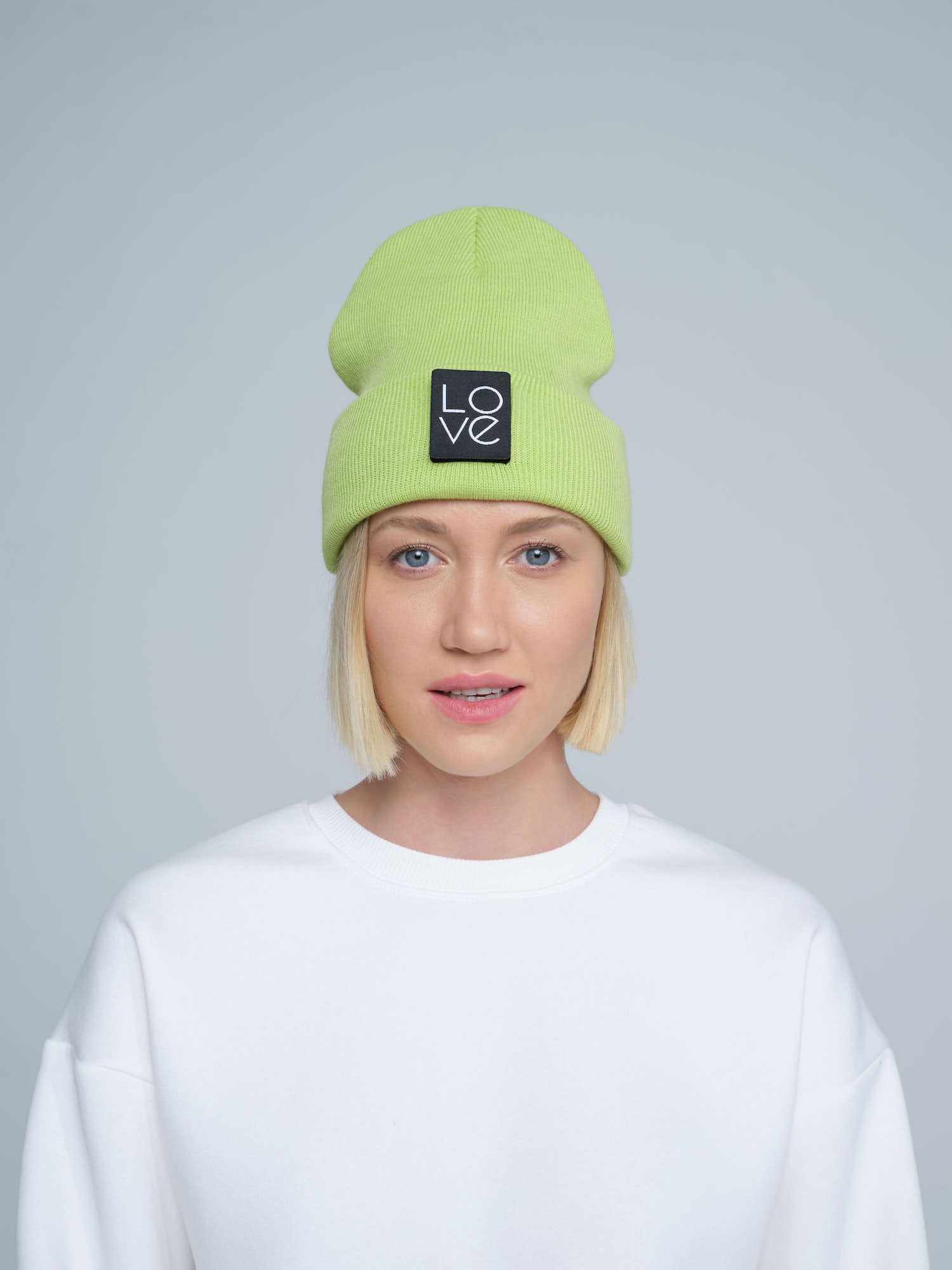 model wearing light green patch ready beanie with LOVE text patch on the front 
