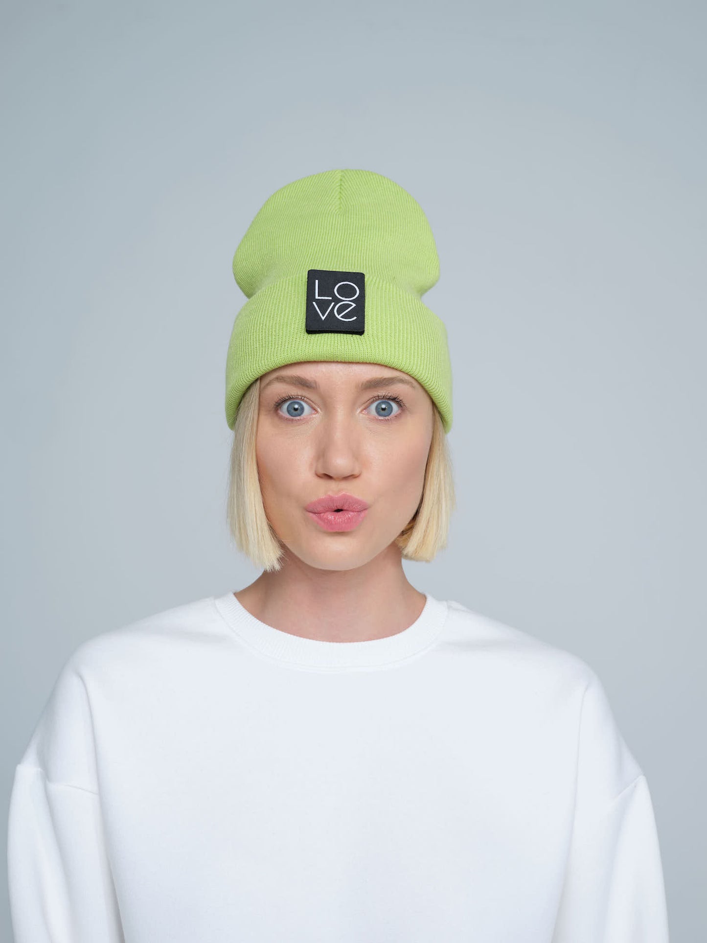 model wearing light green patch ready beanie with LOVE text patch on the front 