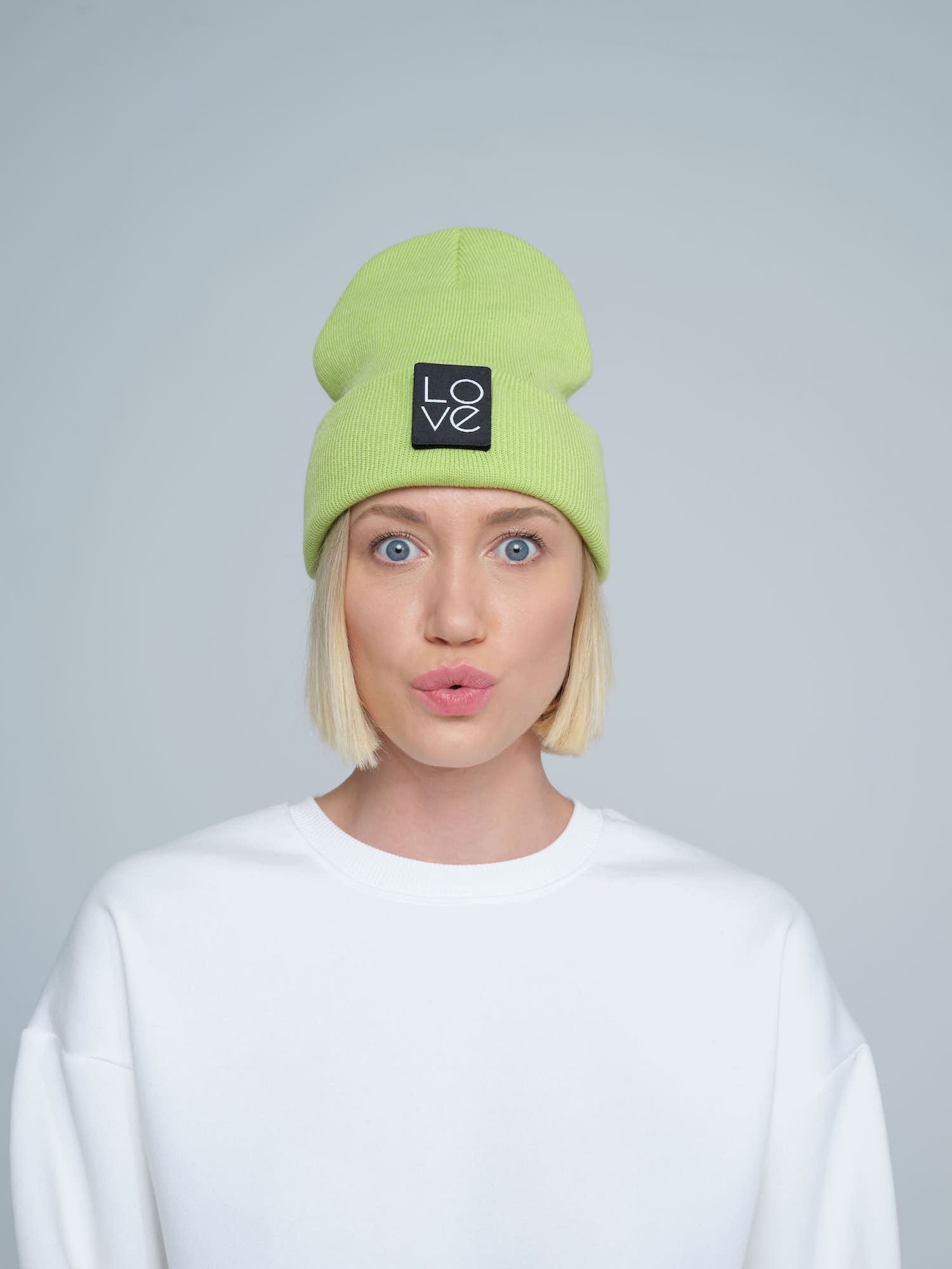 model wearing light green patch ready beanie with LOVE text patch on the front 