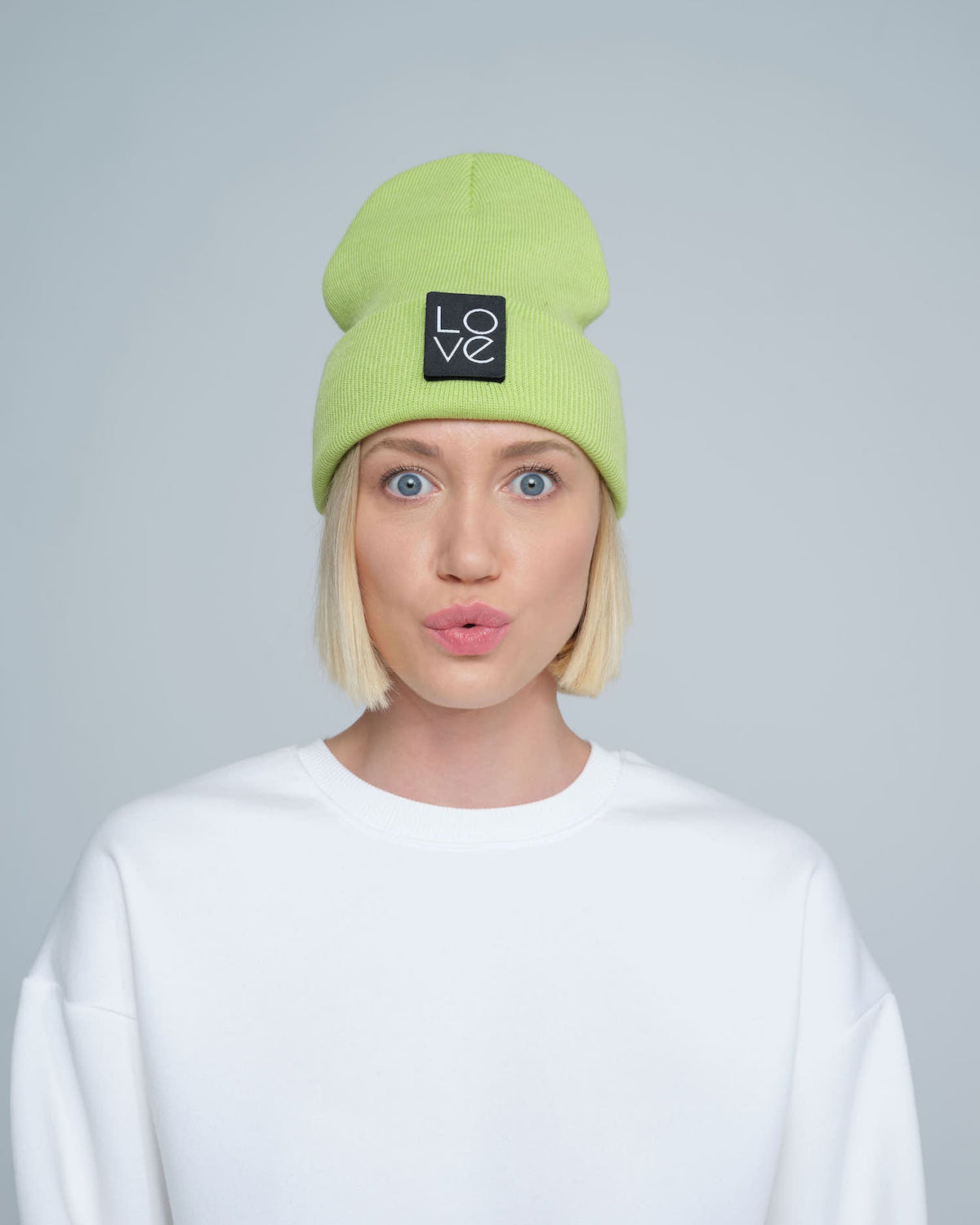 model wearing light green patch ready beanie with LOVE text patch on the front 
