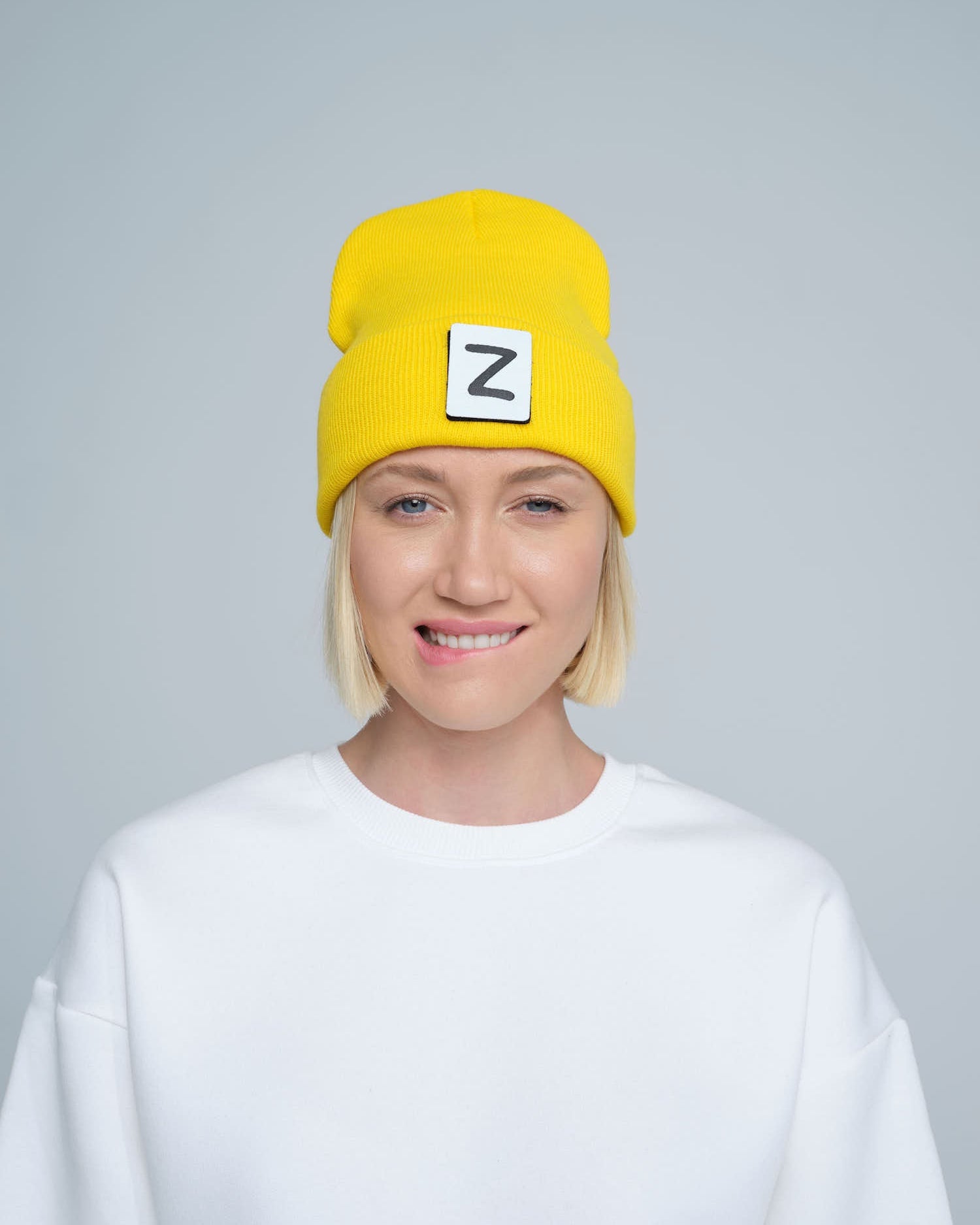 front look of women wearing yellow beanie with Z patch tagged on the front 