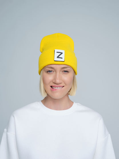 front look of women wearing yellow beanie with Z patch tagged on the front 